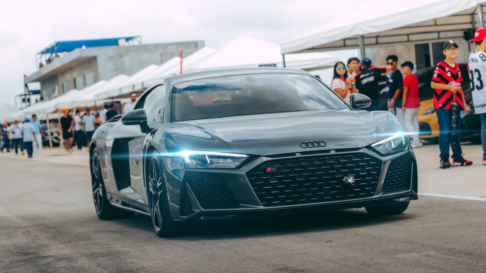 Sleek Audi R8 showcased at an outdoor automotive event with spectators.