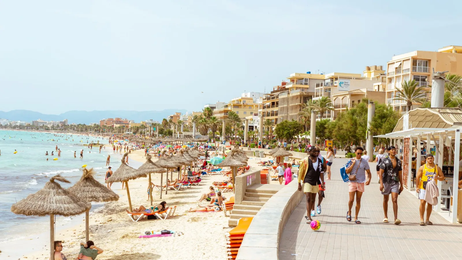 Sunny day at a bustling Ibiza beach with people enjoying leisure activities. Ideal for vacation and tourism content.