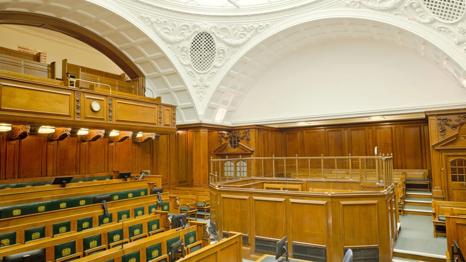 Interior view of a historic courtroom in London with ornate design and wooden furnishing.