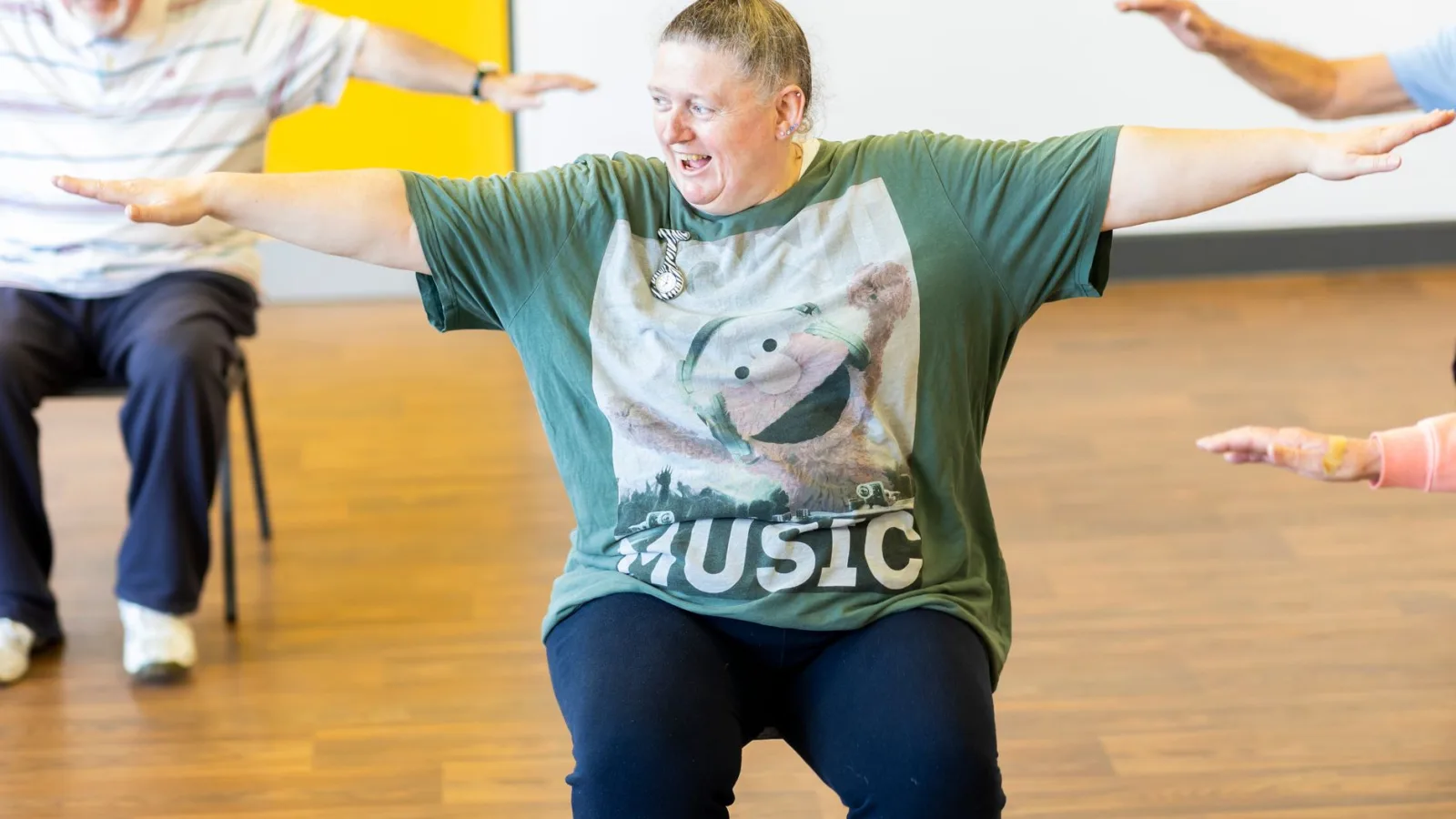 Seniors participating in a seated exercise class, promoting community health and active aging.