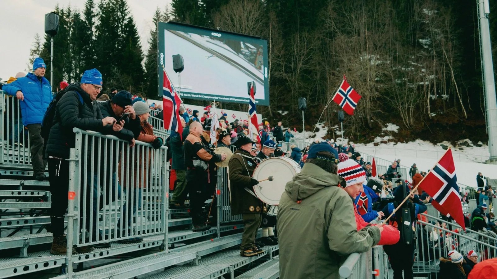 A lively crowd with flags at a winter sports event in Norway, showcasing national pride.