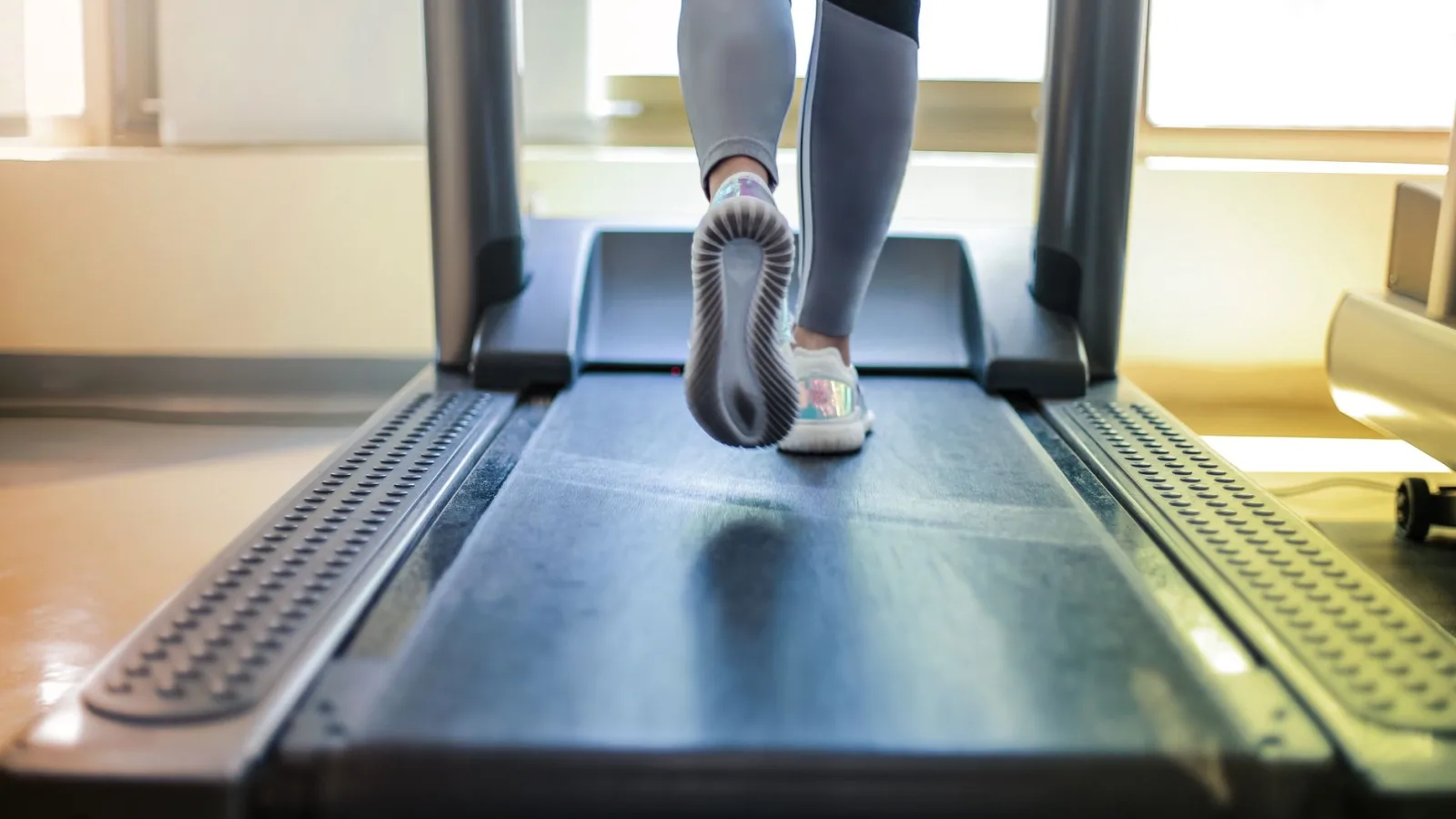 Close-up shot of a person exercising on a treadmill, showcasing fitness and health focus.