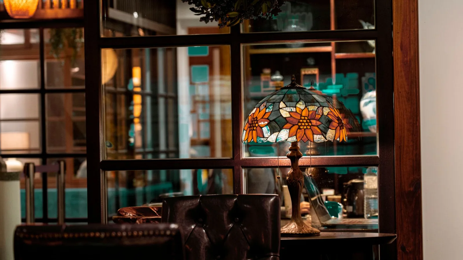 Warm, inviting indoor area featuring a stained glass lamp on a wooden table.