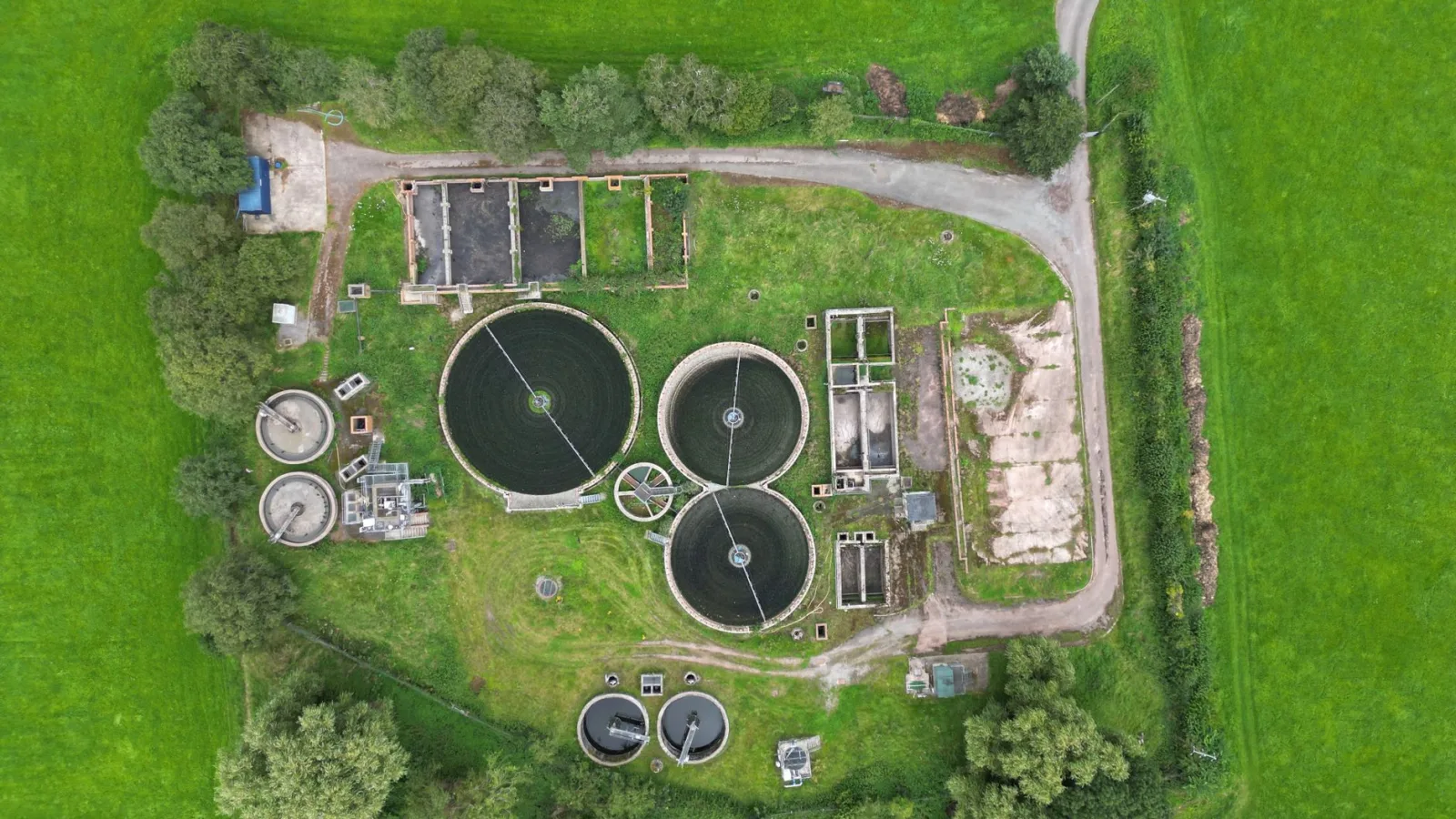 Aerial view of a wastewater treatment plant surrounded by lush greenery in Crickhowell, Wales.
